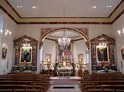 Vue intérieure de la nef vers le chœur et les autels.