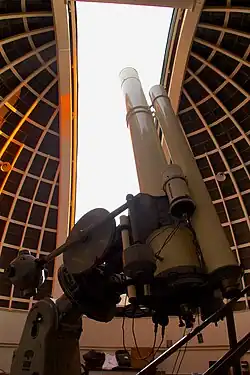 Un télescope devant une coupole ouverte.