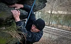 Grimpeur sur une falaise en extérieur par temps froid.