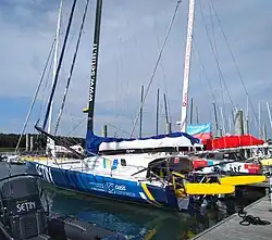 Vu de trois quarts arrière, bateau bleu amarré au ponton.