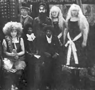 Photographie d'une troupe de cirque dont une femme aux cheveux crépus et deux autres albinos.