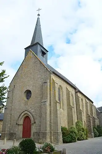vue d'une église, fronton et côté, en granit avec clocher pointu, sur fond de ciel bleu et nuageux.