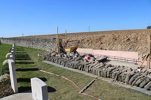 Reconstruction du mur en moellons en mars 2022.