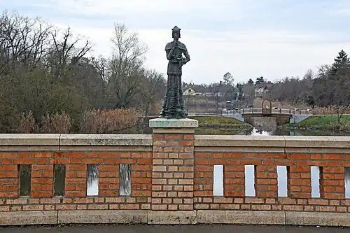 Statue de Saint Jean Népomucène, Gyoma. La statue en bronze, érigée en 1994 sur le parapet sud en briques du pont Erzsébet qui enjambe le Körös à Gyoma, a été créée par György Kiss&nbsp;(hu)