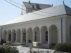 Porche ouvert, formé par neuf arcades à colonnes ; le toit est en ardoise noir.