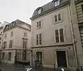 Pavillons sur rue entourant la grille d'entrée