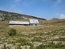 Bergerie isolée dans un terrain de montagne mi-rocheux mi-herbeux.