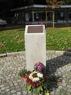 photographie en couleur d'une stèle commémorative rectangulaire entourée de pelouse