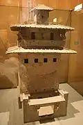 Maquette en céramique d'un entrepôt de stockage de grains avec des fenêtres et un balcon situé plusieurs étages au-dessus de la cour