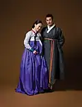Hanbok (costume traditionnel): Une femme portant un jeogori (veste) serré et une chima&nbsp;(en) (jupe) / Un homme en durumagi (manteau traditionnel)