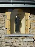 Statue saint Meen dans le mur du lavoir.