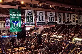 Photo de l'intérieur du Hartford Civic Center avec au premier plan, la bannière de champion de la division Adams 1986-87 des Whalers de Hartford et les 6 maillots retirés de ces mêmes Whalers : de gauche à droite, les numéros 19, 11, 10, 9, 5 et 2.