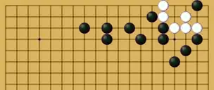 Diagramme montrant un petit groupe de pierres blanches dans un coin confinées de loin par six pierres noires de quatrième ligne