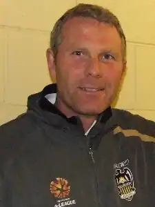 portrait en buste d'un homme aux cheveux roux en survêtement vert