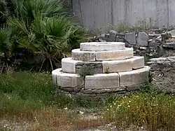 photo couleurs : petite estrade en marbre blanc au milieu d'herbes hautes.
