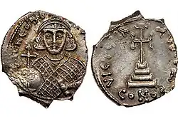 Deux faces d'une monnaie en argent représentant un empereur couronné sur une face et une croix sur une autre.