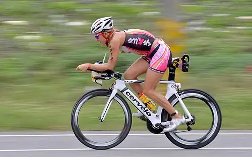 Une cycliste en position aérodynamique sur son vélo.