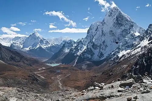Dans le Khumbu, le sommet du Cholatse vu depuis la passe de Cho, plus loin dans la perspective du petit lac le sommet d'Ama Dablam. Quelques nuages cirrus dans le ciel bleu. Octobre 2009.