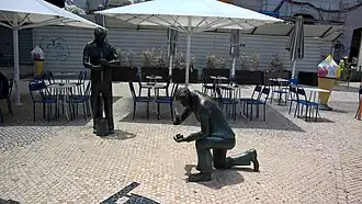Hommage aux calceteiros, du sculpteur Sérgio Stichini devant l'prismes de trottoir&nbsp;(en), Baixa, Lisbonne