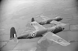 Photographie en noir et blanc de deux avions militaires en plein vol