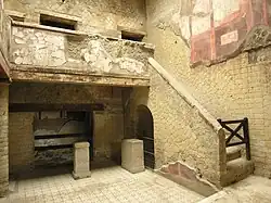 cour intérieure pavée, escalier à droite, balcon à l'étage
