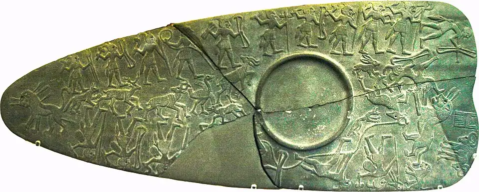 Palette de la chasse ; trois étendards se trouvent sur cette palette : le faucon Horus en haut à droite et en bas à droite, le signe de l'Est en haut au centre.