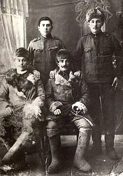 Photographie ancienne en noir et blanc montrant des hommes posant debout ou assis.