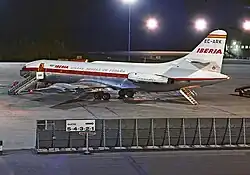 photo de nuit, caravelle stationnée. La rampe arrière est abaissée, et une passerelle positionnée sur la porte gauche.