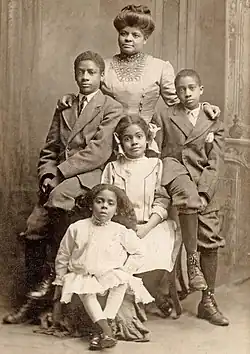 Photo familiale noir et blanc d'une famille noire composée d'une mère et de ses quatre enfants en 1909