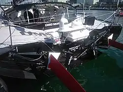 Vue arrière du cockpit et du tableau arrière. Sur ce dernier on peut lire, en blanc sur noir : « Spirit of Yukoh V ». En dessous : « Global One ». Enfin, en dessous : « LO », qui désigne le port d'attache, Lorient.