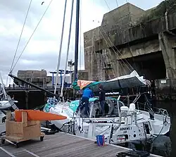 Vu de trois quarts arrière, bateau blanc et vert amarré au ponton.