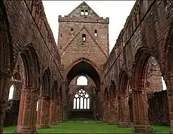Photographie couleur de la nef ruinée d'une église gothique.