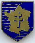 Insigne de la 2e&nbsp;division blindée fabriqué en Angleterre avant son débarquement en Normandie. Cet emblème représente la France, avec en son centre la croix de Lorraine.