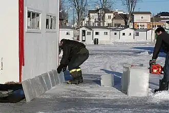 Rechaussement d’une cabane avec de la glace, qui sera recouverte de neige