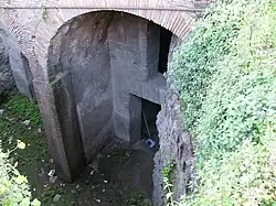 Rez-de-chaussée, portique en arcade et entrée de boutique.