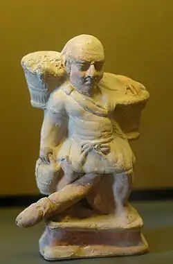 Esclave nain ithyphallique portant deux paniers. Terre cuite, Myrina (Mysie), (Ier&nbsp;siècle&nbsp;av. J.-C.).
