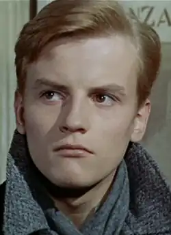 Photographie d'un jeune homme blond aux traits fins et à l'air préoccupé.