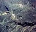 Photo couleur du cratère d'un volcan, recouvert de verdure, vue d'avion.