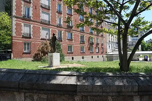 Une partie du jardin avec la statue en arrière-plan.
