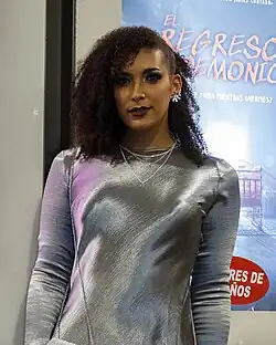 Femme mate de peau en combinaison regardant la caméra