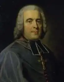 Peinture à l'huile représentant un homme d'église vêtu d'une soutane, le cou entouré d'un collaro noir, sa tête couverte d'une perruque blanche et bouclée.