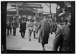 photo d'une homme âgé en uniforme de l'armée française, il est en extérieur et sort d'un sanctuaire shinto, un torii est visible.