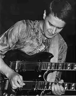 John McLaughlin jouant sur une guitare double manche.