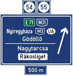 Panneau d'avertissement de sortie d'autoroute à 500 mètres sans affectation de voies (numéro et nom de la sortie)