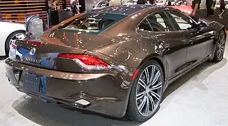 Photo de 2/4 face arrière d'une voiture de luxe marron dans un stand d'exposition.