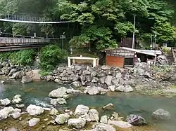 Photo couleur d'un bain public le long d'un cours d'eau.