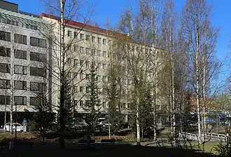 Immeuble de bureaux au coin de Kirkkokatu et de Hallituskatu. À l'avant plan, le parc Snellman.