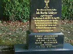 Une pierre tombale noire avec des inscriptions dorées pour J. M. Schleyer (texte en allemand avec une phrase en volapük) et deux autres personnes.