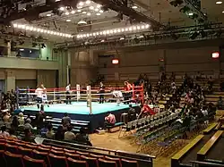 Vue sur un ring de boxe dans une salle à moitié vide.