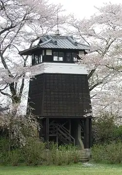 Tour carrée en bois au milieu d'arbres en fleur